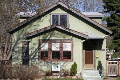 Example of an arts and crafts green two-story stucco exterior home design in Minneapolis