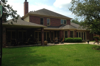 Inspiration for a large timeless red two-story brick exterior home remodel in Houston with a shingle roof