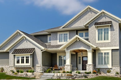 Imagen de fachada de casa gris de estilo americano grande de dos plantas con revestimientos combinados, tejado a dos aguas y tejado de teja de madera