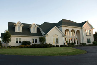 Large elegant white two-story stucco exterior home photo in Milwaukee with a shingle roof