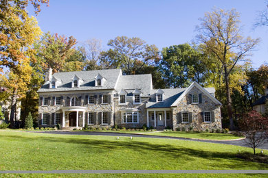 Example of a huge classic three-story stone exterior home design in DC Metro