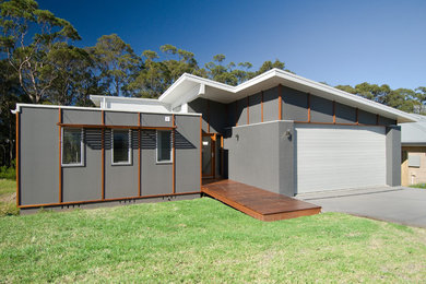 Photo of a large and blue contemporary bungalow concrete house exterior in Sydney with a mansard roof.