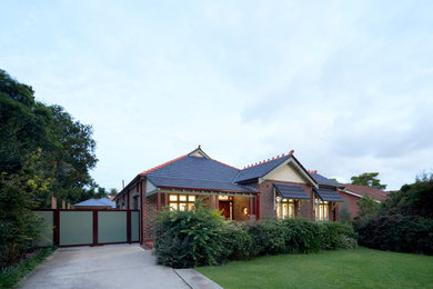 Diseño de fachada marrón tradicional de tamaño medio de una planta con revestimiento de ladrillo, tejado a dos aguas y tejado de teja de barro