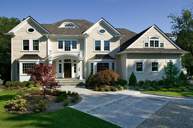Design ideas for a beige and large traditional two floor house exterior in New York with wood cladding.