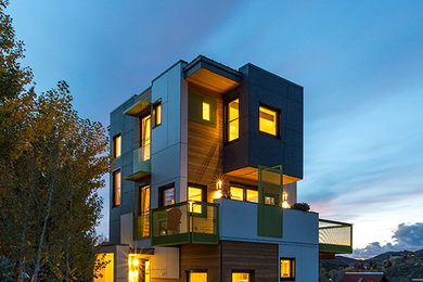 Ejemplo de fachada de casa multicolor moderna grande de tres plantas con revestimientos combinados y tejado plano
