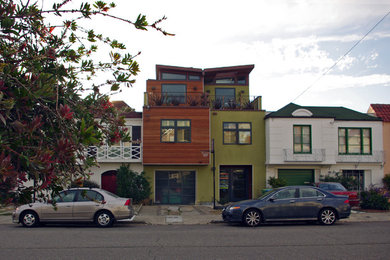 Foto de fachada verde actual de tamaño medio de tres plantas con revestimiento de estuco