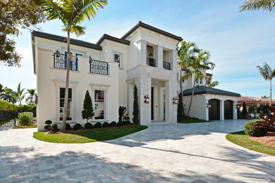 Example of a large tuscan white two-story stucco exterior home design in Miami