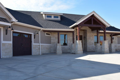 Mid-sized country two-story stone house exterior idea in Denver with a shingle roof and a black roof