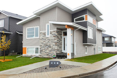 Mid-sized transitional gray one-story mixed siding house exterior photo in Calgary with a shed roof and a shingle roof