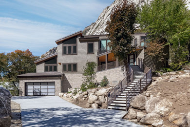 Cette image montre une façade de maison grise minimaliste à deux étages et plus avec un revêtement en vinyle, un toit en appentis et un toit en shingle.