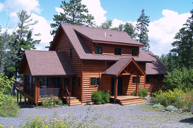 Ejemplo de fachada de casa marrón rural de tamaño medio de dos plantas con revestimiento de madera, tejado a dos aguas y tejado de teja de madera