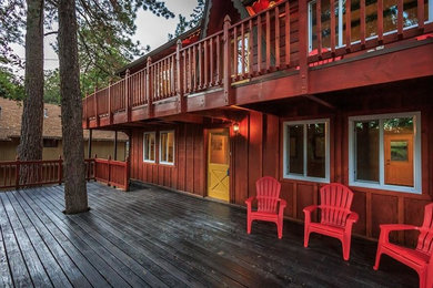 Cette image montre une façade de maison rouge chalet en bois de taille moyenne et à un étage.