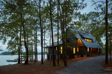 Diseño de fachada de casa negra rústica grande de dos plantas con revestimiento de madera, tejado a dos aguas y tejado de metal