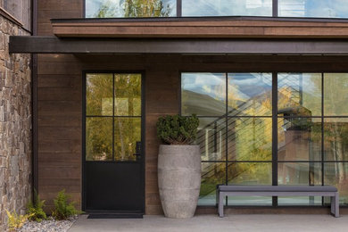 Ejemplo de fachada de casa gris actual grande de dos plantas con revestimientos combinados, tejado a dos aguas y tejado de metal