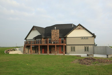 Imagen de fachada de casa gris de estilo americano de tamaño medio a niveles con revestimiento de hormigón, tejado a cuatro aguas y tejado de teja de madera