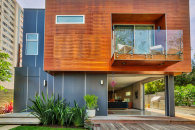 Diseño de fachada de casa gris minimalista grande de dos plantas con revestimiento de madera y tejado plano