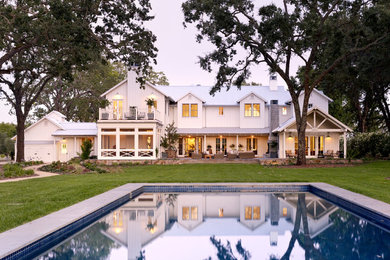 Ejemplo de fachada blanca de estilo de casa de campo grande de dos plantas con revestimiento de madera