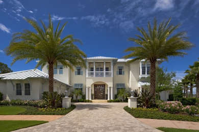 Example of a beach style white two-story stucco exterior home design in Orlando