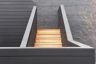 Imagen de fachada negra contemporánea con revestimiento de madera