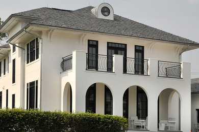 Huge minimalist white three-story stucco house exterior photo in New York with a hip roof and a shingle roof