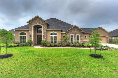 Large tuscan beige two-story stone exterior home photo in Houston