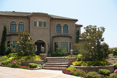 ロサンゼルスにある高級なトロピカルスタイルのおしゃれな家の外観 (混合材サイディング) の写真