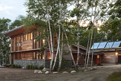 Imagen de fachada rústica de dos plantas con revestimiento de madera y tejado de un solo tendido