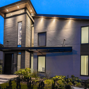 Foto de fachada de casa gris, moderna, de tamaño medio, de tres plantas, con revestimientos combinados y tejado de un solo tendido