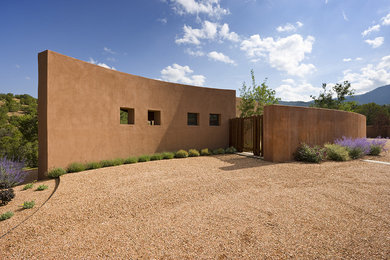 Ejemplo de fachada marrón contemporánea grande de una planta con revestimiento de estuco y tejado plano
