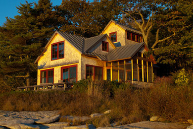 Medium sized beach style two floor house exterior in Boston with wood cladding.