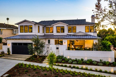 Beach style white two-story house exterior photo in Orange County with a hip roof and a mixed material roof