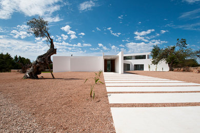 Imagen de fachada blanca mediterránea extra grande de una planta con revestimiento de estuco y tejado plano