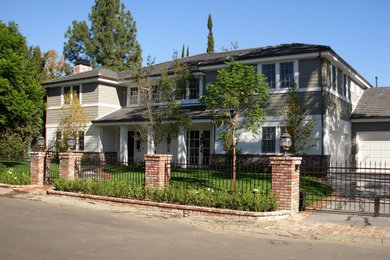 Imagen de fachada de casa gris costera grande de dos plantas con revestimiento de vinilo, tejado a dos aguas y tejado de teja de barro