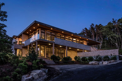 Imagen de fachada de casa marrón contemporánea grande de dos plantas con revestimiento de madera y tejado plano