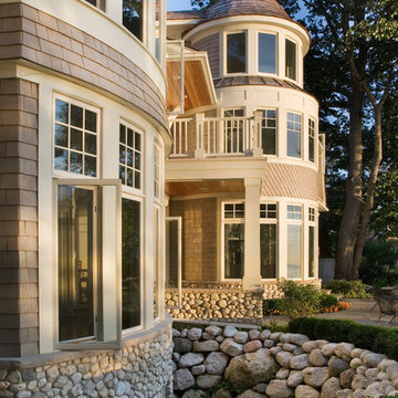 Cape Cod Stone and Shingle Style House with Contrived English Window Wells