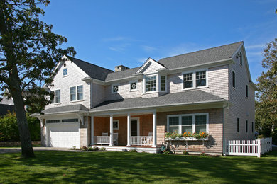 Example of a huge beach style beige two-story wood gable roof design in Boston