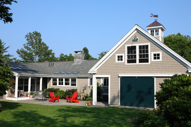 Imagen de fachada de casa beige tradicional de tamaño medio de dos plantas con revestimientos combinados, tejado a dos aguas y tejado de teja de madera