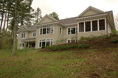 Modelo de fachada de casa verde clásica grande de dos plantas con revestimiento de madera, tejado a dos aguas y tejado de teja de madera