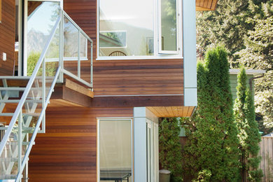 Ejemplo de fachada marrón actual de tamaño medio de dos plantas con revestimiento de madera y tejado plano