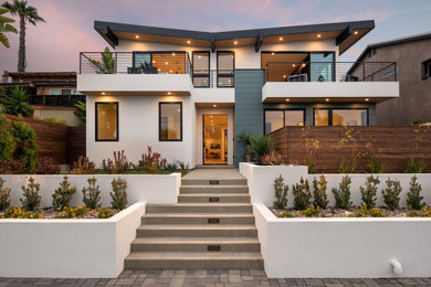 Inspiration pour une grande façade de maison verte minimaliste en panneau de béton fibré à niveaux décalés avec un toit en appentis et un toit en métal.