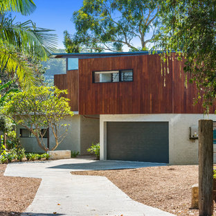 Photo of a large contemporary two-storey brown house exterior in Sydney with wood siding, a metal roof and a shed roof.
