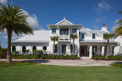 Inspiration for a large tropical white two-story stucco house exterior remodel in Jacksonville