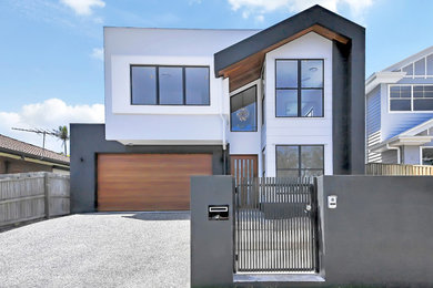 Modelo de fachada de casa multicolor moderna de tamaño medio de dos plantas con revestimiento de aglomerado de cemento, tejado plano y tejado de metal
