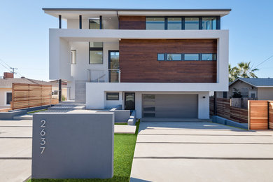Imagen de fachada de casa moderna grande de tres plantas con revestimiento de estuco