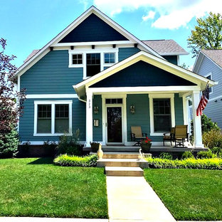 Modelo de fachada azul, de estilo americano, pequeña, de dos plantas, con revestimiento de madera, tejado a dos aguas y tejado de teja de madera