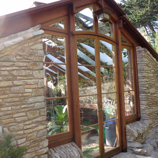 Modelo de fachada marrón, clásica renovada, grande, de una planta, con revestimiento de piedra y tejado a dos aguas