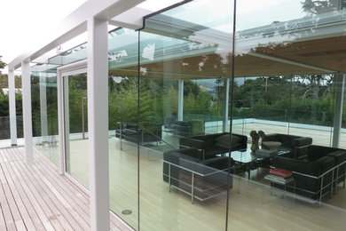Large minimalist white two-story glass flat roof photo in San Francisco