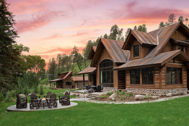 Imagen de fachada de casa marrón rústica grande de dos plantas con revestimiento de madera y tejado de metal