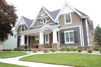 Diseño de fachada de casa marrón de estilo americano de tamaño medio a niveles con revestimiento de metal, tejado a cuatro aguas y tejado de teja de madera
