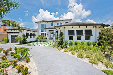 Large trendy white two-story stucco house exterior photo in Tampa with a hip roof, a tile roof and a brown roof